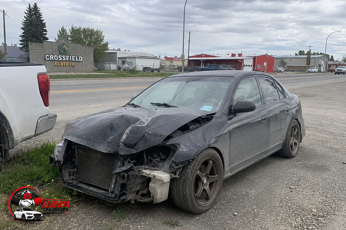 A black wrecked car parked.